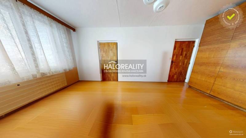 A room in a 3-room apartment with a wood-patterned floor, a large window, and a built-in wardrobe.