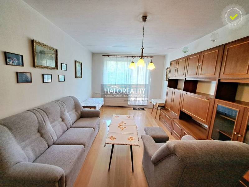 Living room with light, wood-patterned flooring, and furniture in a three-room apartment.
