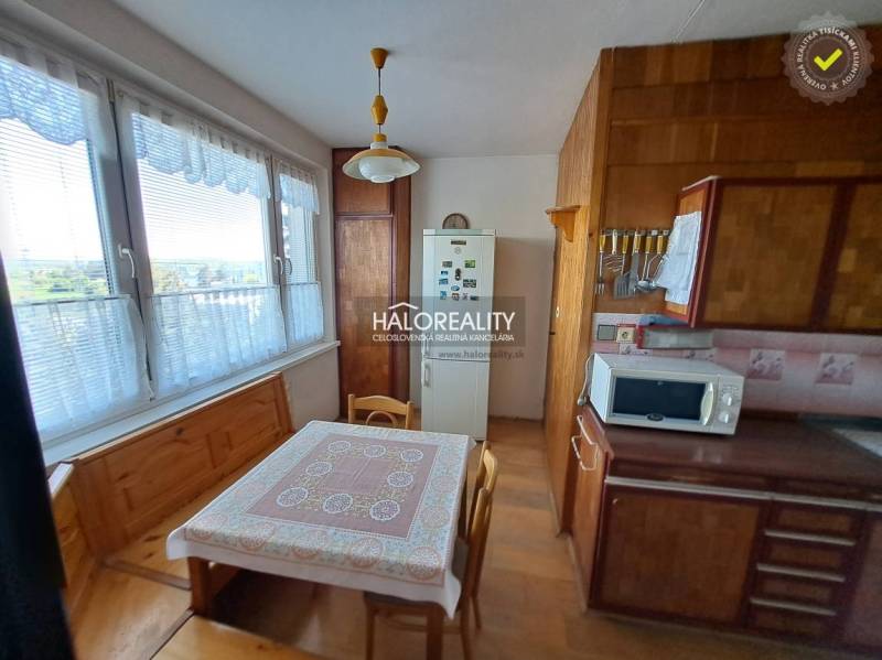 Living room in a three-room apartment with a wooden decor floor, a sofa set, and wall decorations.