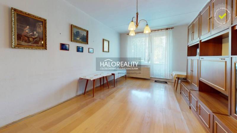 A kitchen in a 3-room apartment with the original cabinetry and flooring with a wood design.
