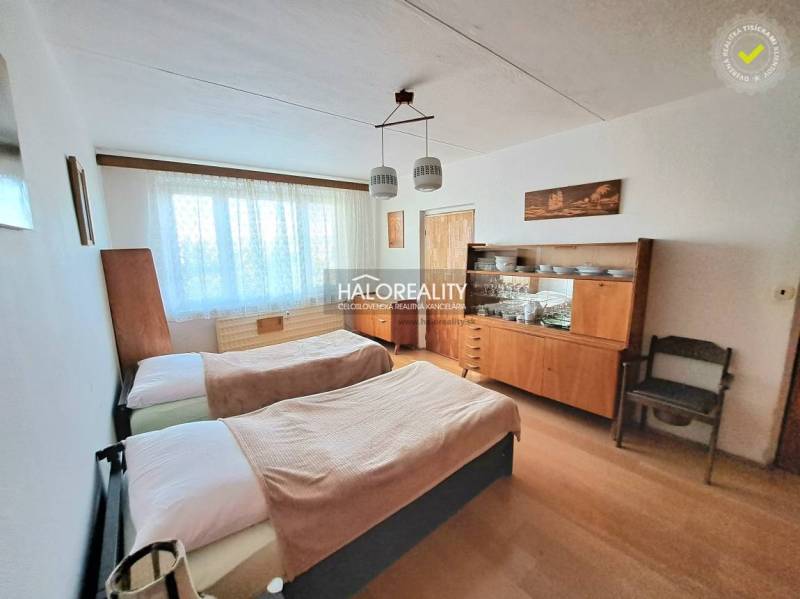 A bedroom in a 3-room apartment with two beds and a wooden decor floor.