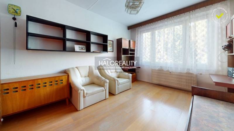 A kitchen in a 3-room apartment with a wood-patterned floor and window seating.