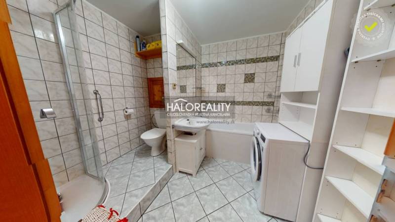Bathroom in a 2-room apartment with a bathtub, shower, and washing machine.