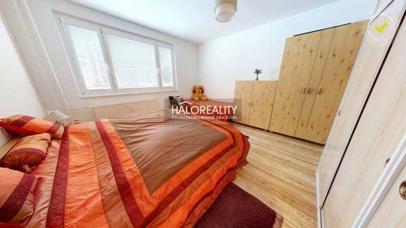 A bedroom in a 2-room apartment with a bed, a wardrobe, and a wooden decor floor.