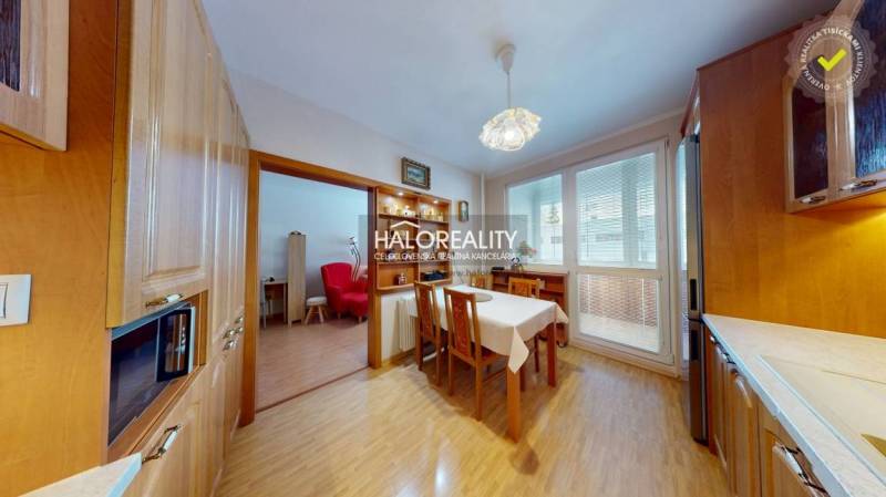 Dining room with kitchen in a two-room apartment. Floor with wood decor, spacious windows.