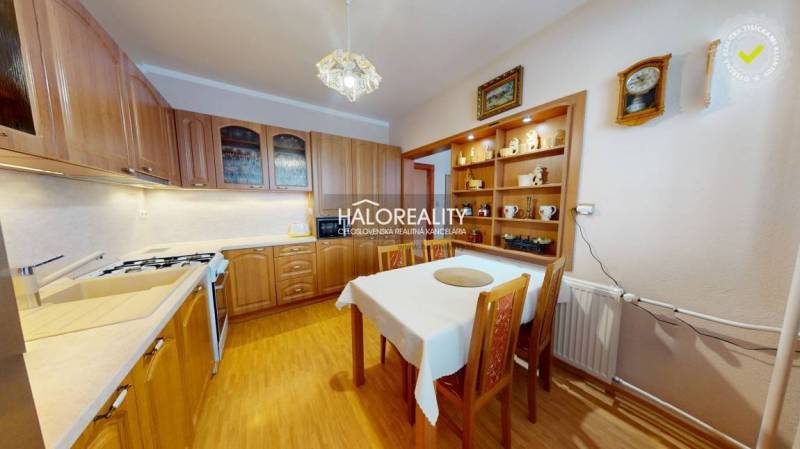 A kitchen in a 2-room apartment with a dining table and a floor with a wood decor.