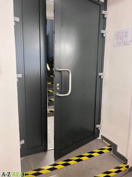 Opening metal doors in commercial premises, behind which are stairs.