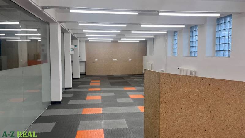 Commercial spaces with divided rooms, gray-orange flooring, and glass walls on Račianska.