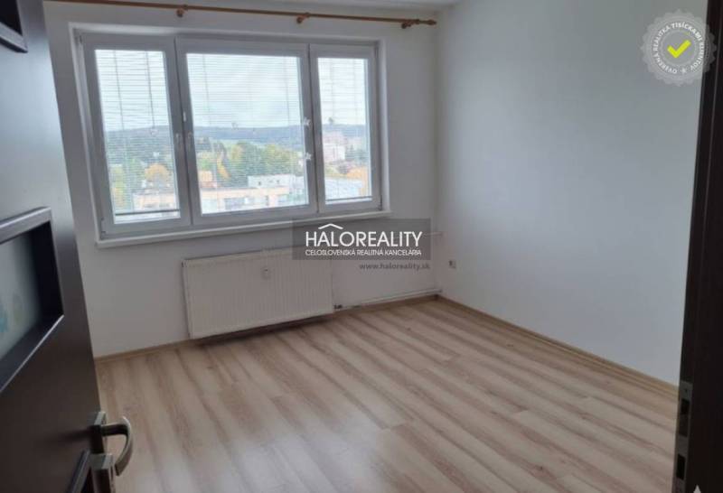 A bright room in a 3-room apartment with a wooden decor floor and a large window.