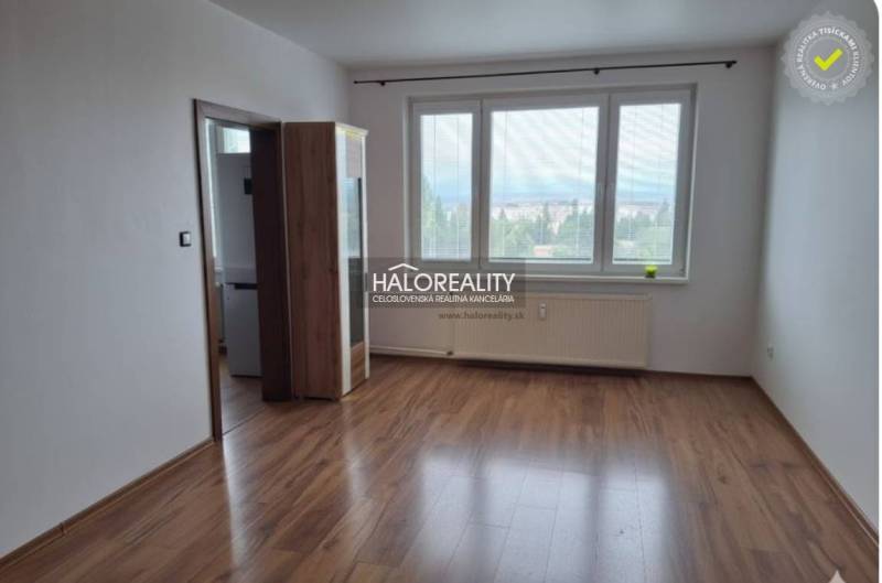A room with a wooden decor floor and large windows in a 3-room apartment.