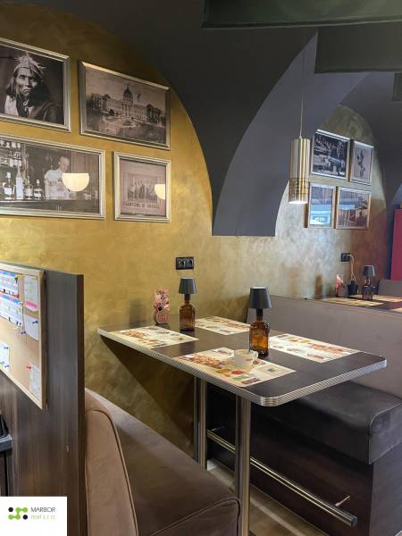 Interior of gastro spaces with wooden decor and historical photographs on the walls.