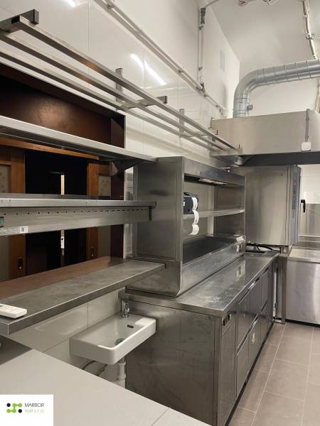 A kitchen in a gastro space with stainless steel equipment and a sink.