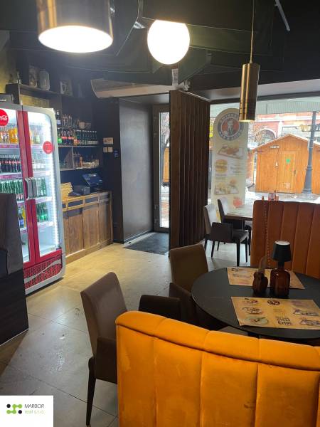 Interior of dining spaces with a round table, chairs, and lighting.