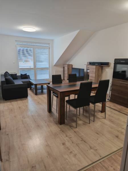 Living room in a 3-room apartment with a wooden decor floor and a dining table.
