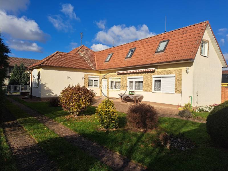 A family house on Bernolákova Street in Vráble, surrounded by a green garden and a blue sky.