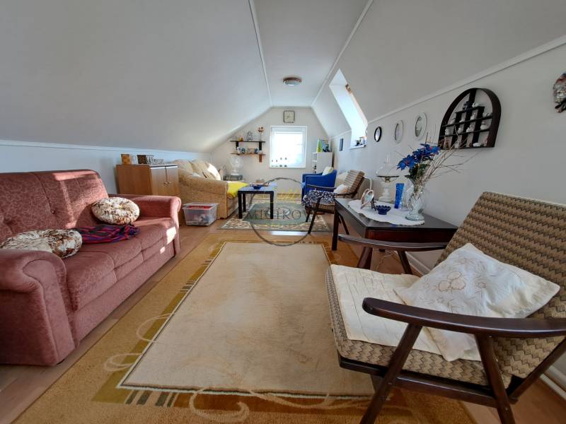 Attic living room in a family house with a sofa bed and decorative accessories.