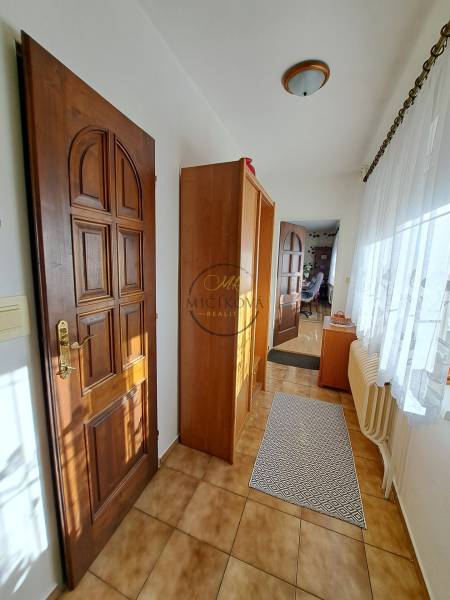 Interior of a family house with tiles, wooden doors, and a glass wall.