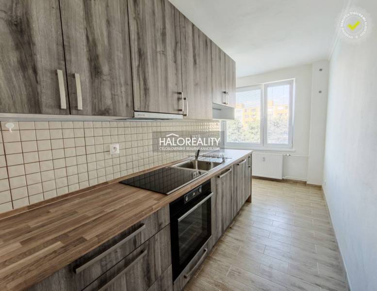 A kitchen in a 2-room apartment with a kitchen unit and a floor with a wooden decor.