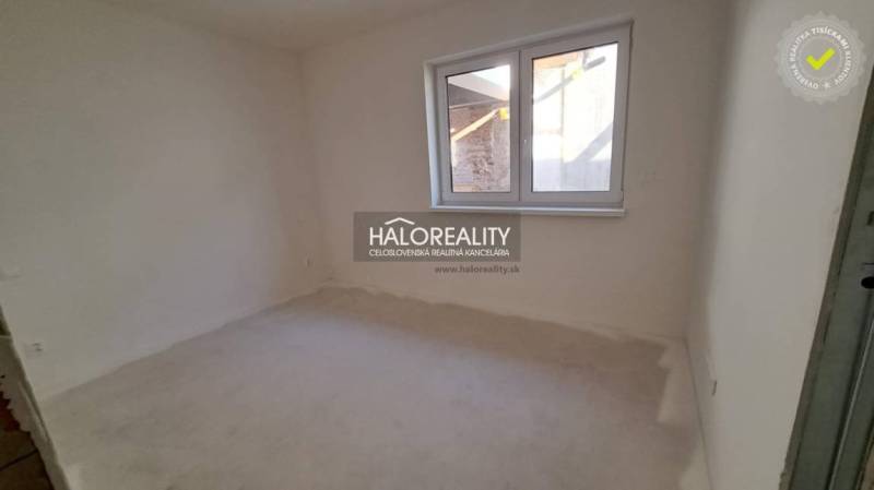 Empty room with white walls and a large window in a family house.