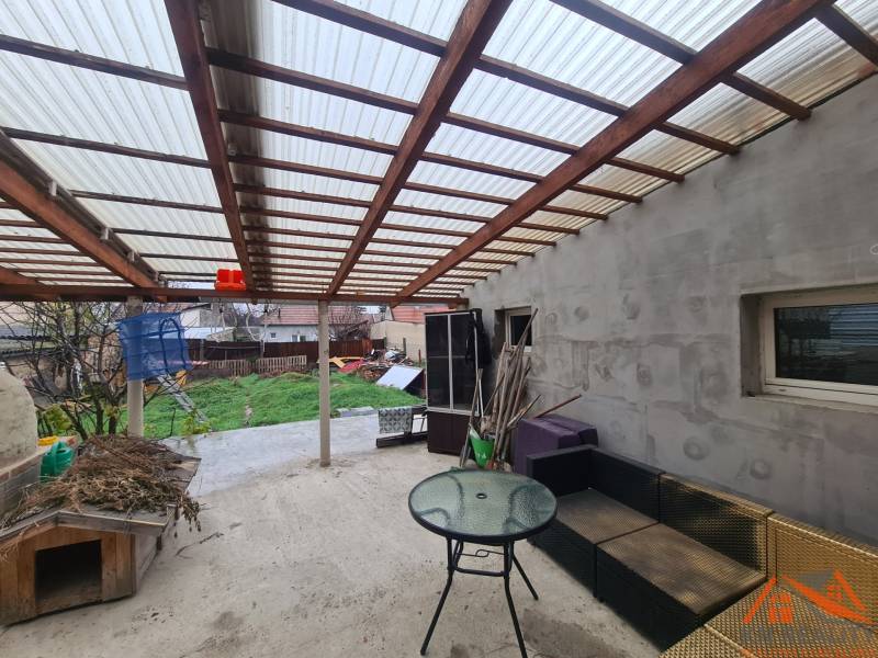 The terrace of a family house in Komárno with garden furniture and a shelter.