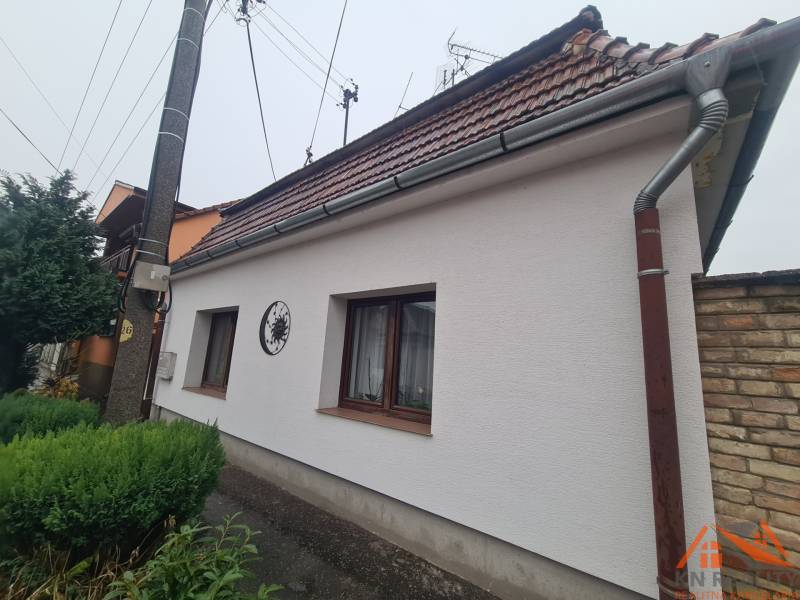 A family house in Komárno with a sloped roof and a landscaped garden.