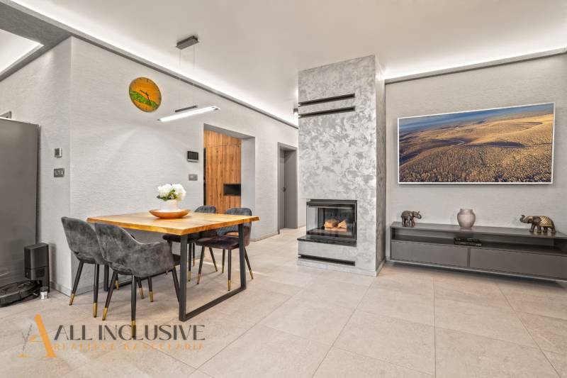 Living room in a family house with a fireplace, a table for four, and decorations.