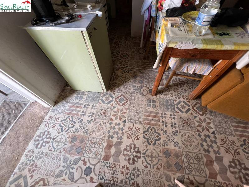 Interior in a family house with colorful tiles and a table with a patterned tablecloth.