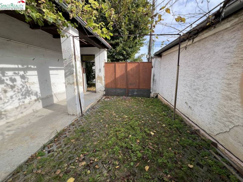 The courtyard of a family house in Jablonec with stone paving and greenery.