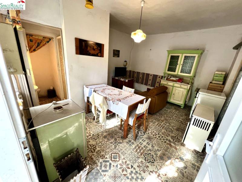Interior of a family house with a ceramic floor, kitchen unit, and dining table.