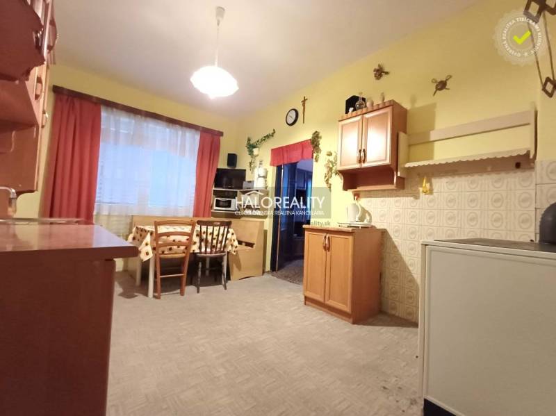 A kitchen in a family house with wooden decor, light walls, a table with chairs.