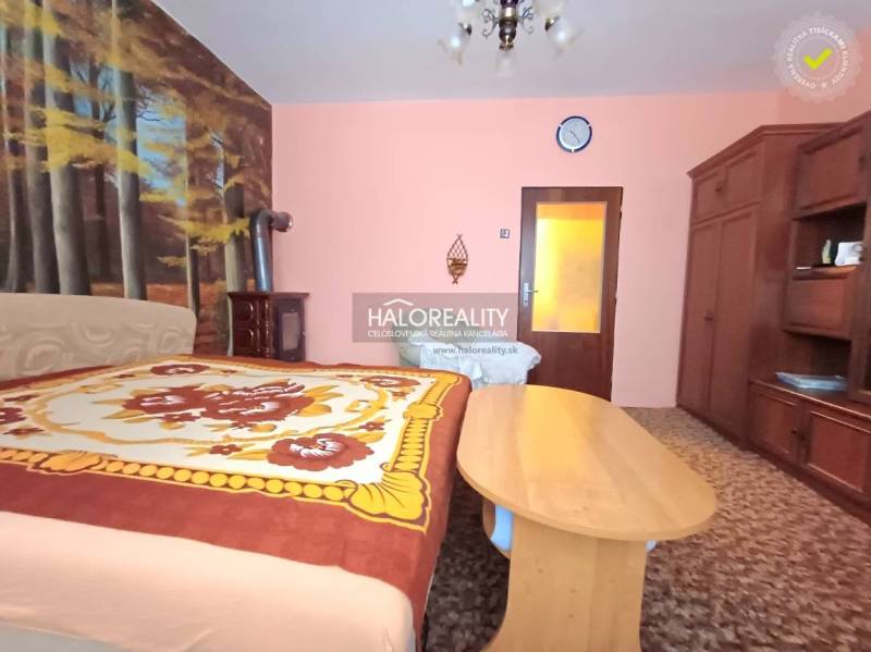 A bedroom in a family house with a forest wallpaper and classic wooden furniture.