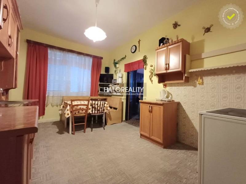 A kitchen in a family house with a wooden decor, dining table, and cabinets.