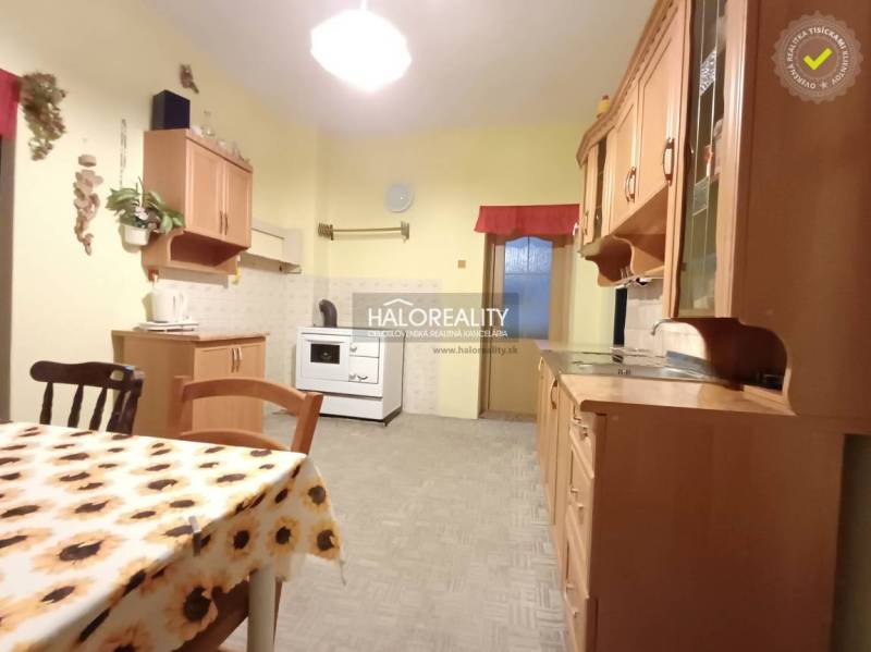 Kitchen in a family house with a dining table and wooden cabinets.