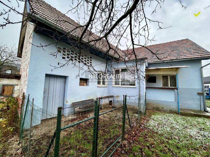 A family house in Prievidza with a blue facade and fencing on a smaller plot.