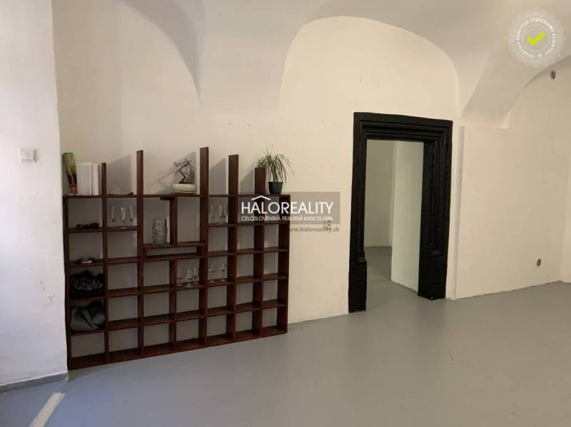 The interior of an office with ceiling arches and a wooden bookshelf.