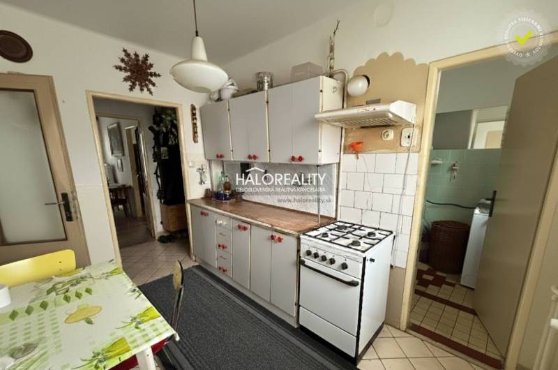 Kitchen in a 3-room apartment with a gas stove and a dining area.