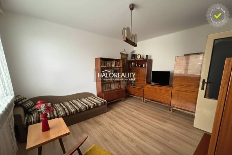 Living room in a 3-room apartment with a wooden decor floor, wooden furniture, sofa.