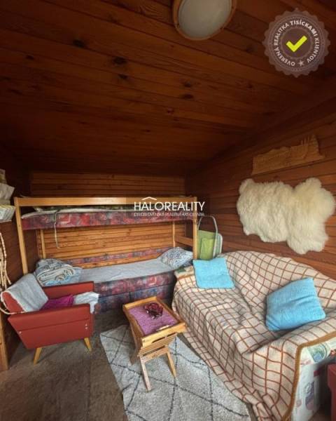 A room with a sofa, a bunk bed, and a wooden-patterned floor in the Gardens.