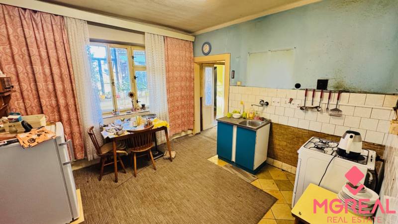 A kitchen in a family house with a dining table, a gas stove, and a sink.