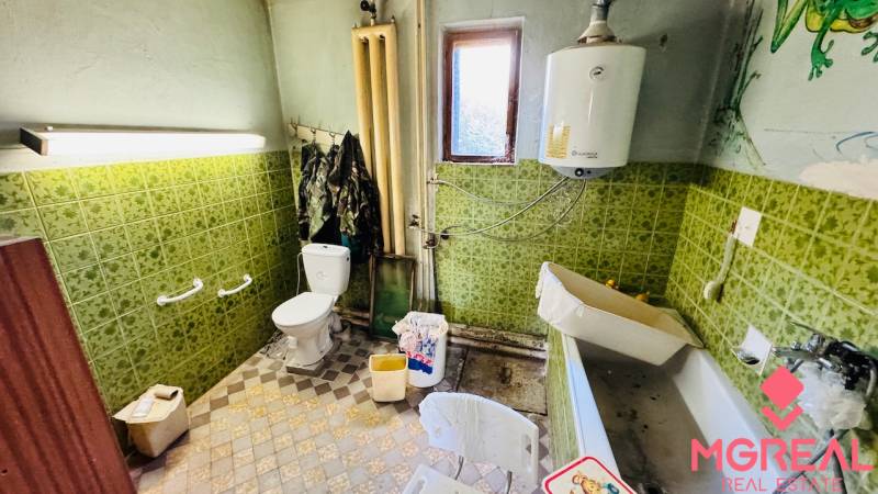 A bathroom in a family house with ceramic tiles and older equipment.