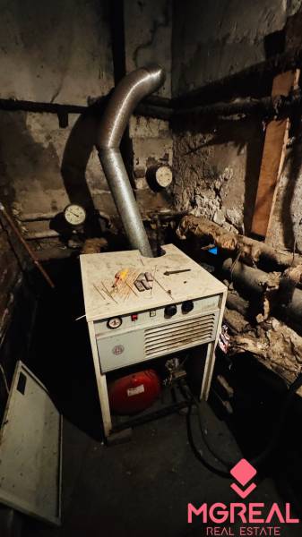 Boiler room in a family house with measuring instruments and a steel chimney.
