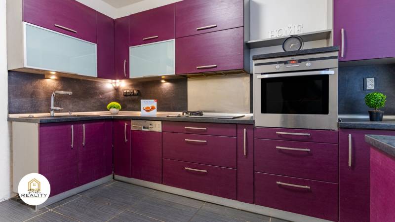 A kitchen with purple cabinets and modern equipment in a 4-room apartment.