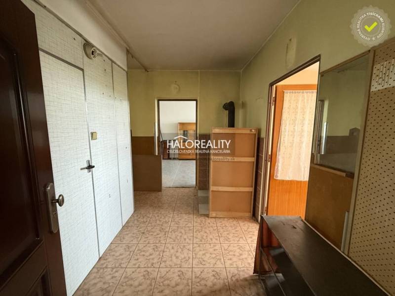 A hallway in a 3-room apartment with wooden and white elements on the walls.