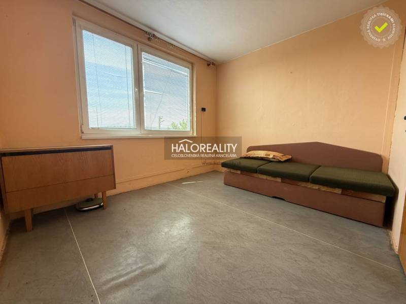 A bright room with a sofa in a three-room apartment, wooden furniture, large window.