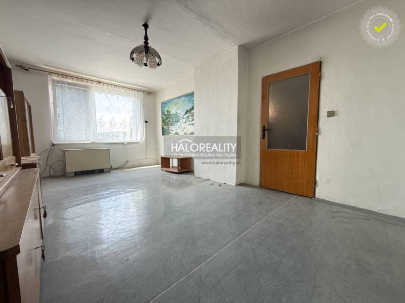 Spacious living room in a 3-room apartment, white wall, wooden doors and furniture.