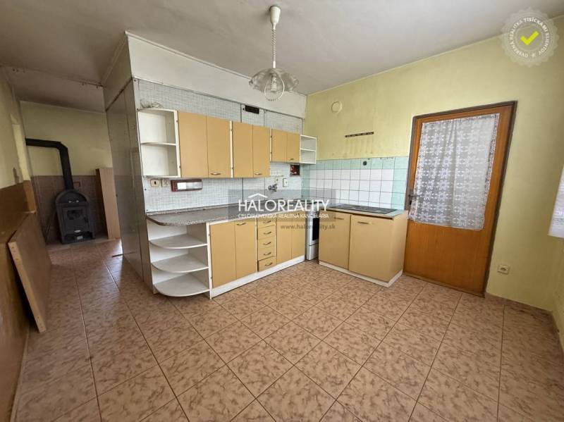 A kitchen with tiles and a wooden cabinet in a 3-room apartment.