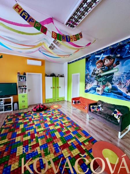 A colorful children's playroom with a poster on the wall, a wooden decor floor, and festive decorations.