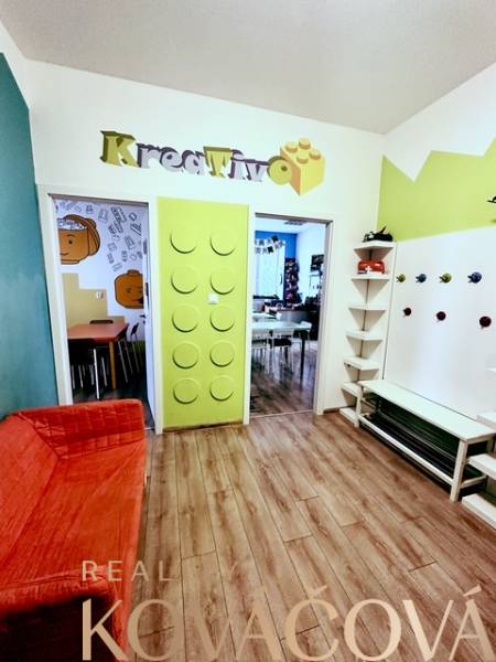 Colorful office interior with wood-patterned flooring and a creative entrance design.