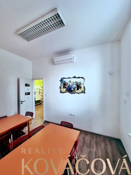 Offices with wood-patterned flooring, desks and chairs, wall painting.