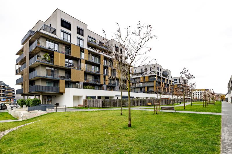 Apartment complex on Fialová Street in Bratislava - Petržalka with manicured lawn and benches.